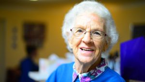 Elderly woman in blue top smiling